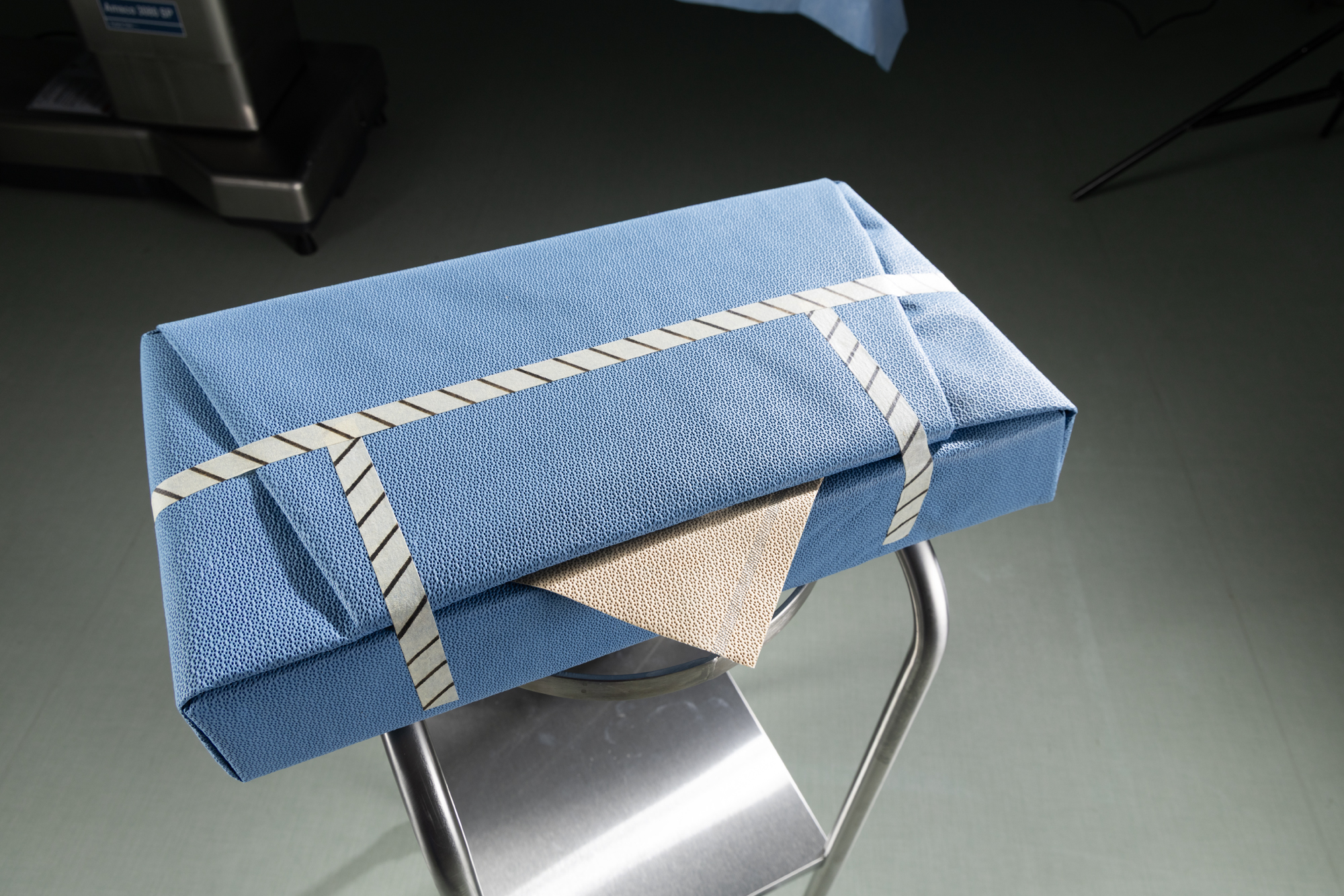Amber ASSURE-DRY binnenlaag van ARMOR-FLEX wrap wordt teruggetrokken over een gesteriliseerd instrumentenbakje